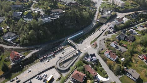 Imagen-Fija-Del-Tren-Ligero-En-La-Estación-De-Mårdalen,-Con-El-Tráfico-Pasando-Por-Las-Afueras-De-Nesttun-En-Bergen.