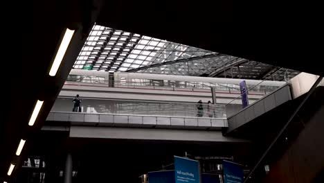 Dentro-De-La-Estación-Principal-De-Trenes-Hauptbahnhof-De-Berlín-Con-Un-Techo-De-Cristal-Futurista-Que-Se-Extiende-Por-Encima-Mientras-El-Tren-De-Hielo-Db-Llega-Al-Nivel-Superior