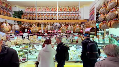 Various-customers-buying-ham-in-local-delicatessen-shop-in-Italy