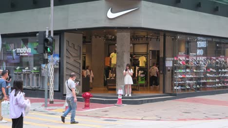 Pedestrians-and-customers-are-seen-in-front-of-the-American-multinational-sports-clothing-brand,-Nike-store