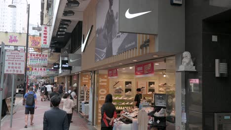 Kunden-Werden-An-Der-Amerikanischen-Multinationalen-Sportbekleidungsmarke-Nike-Store-Gesehen,-Während-Fußgänger-Daran-Vorbeigehen