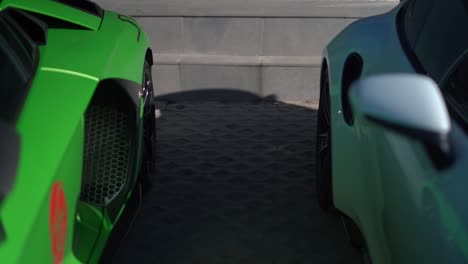 zoom-out-shot-revealing-a-green-Lamborghini-and-a-white-Porsche