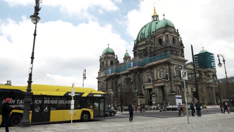 Yellow-Bus-Pulling-Up-To-Stop-Beside-Berlin-Cathedral