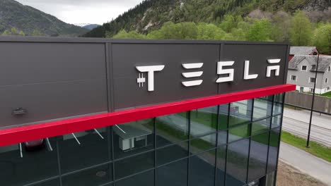 Tesla-logo-on-wall-of-modern-Tesla-car-dealership-building-in-Forde-Norway