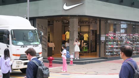 Shoppers-and-pedestrians-are-seen-in-front-of-the-American-multinational-sports-clothing-brand,-Nike-store