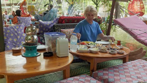 Woman-eats-Turkish-breakfast-at-riverside-restaurant-with-relaxing-atmosphere