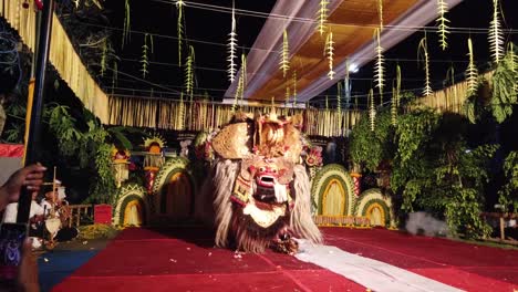 Espectáculo-De-Danza-Enmascarada-De-Barong-En-La-Ceremonia-Nocturna-Del-Templo-De-Bali,-Indonesia,-Con-Música-Gamelan-Y-Adornos-Coloridos-De-Alfombra-Roja