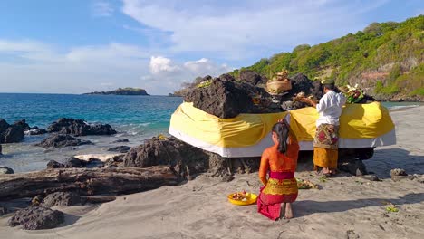 Hindu-women-and-man-praying-on-the-beach-of-Virgin-Beach-Bali-giving-offerings