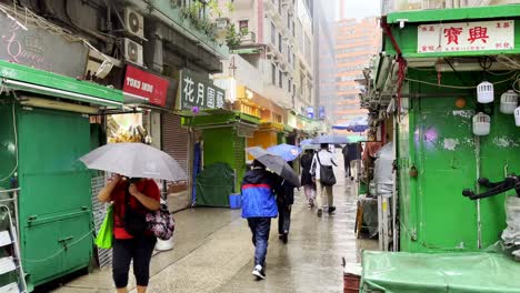 People-walking-on-Tai-Yuen-Street-in-Wan-Chai-during-rain-storm-in-Hong-Kong