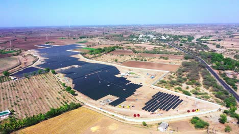 extreme-wide-view-where-the-aerial-drone-camera-rotates-around-a-solar-power-station-that-produces-green-energy-and-delivers-it-to-a-nearby-power-station