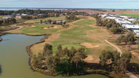 Yarrawonga,-Victoria,-Australia---2-June-2023:-Over-greens-fairways-and-lakes-on-the-Black-Bull-Golf-Course-with-Lake-Mulwala-and-new-homes-in-the-background