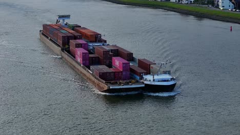 Aerial-View-Of-Arctic-Cargo-Container-Ship-Paired-With-Barge-Travelling-Along-River-Noord