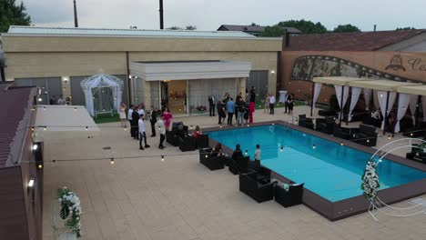 drone-shot-of-people-talking-and-having-fun-near-a-pool