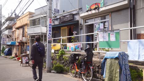 Japanese-Male-Casually-Walking-Past-Yanaka-Ginza-Street-In-Tokyo,-Japan