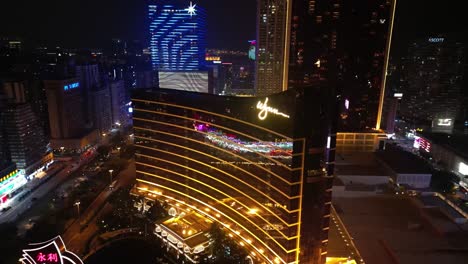 Aerial-view-orbiting-Wynn-Hotel,-Macau-at-night