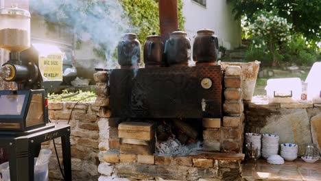 Große-Türkische-Wasserkocher-Brühen-Tee-Auf-Einem-Rauchend-Heißen-Holzofen-Im-Freien