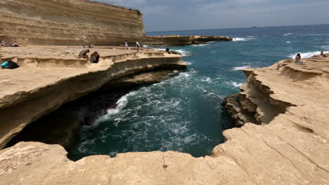 A-rocky-cliff-shore-along-the-Island-nation-of-Malta-with-significant-erosion---tilt-down-reveal