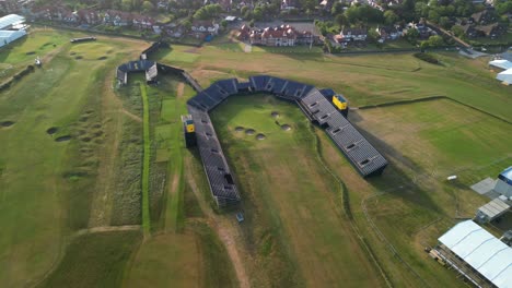 Preparations-for-The-2023-Open-at-Royal-Liverpool-Golf-Club,-Wirral,-UK---Aerial-drone-18th-green-clockwise-pan-from-high