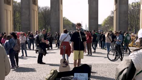 Male-Singer-Performing-To-Crowds-And-Tourists-At-Pariser-Platz-Beside-Brandenburg-Gate-In-Berlin-On-Sunny-Day