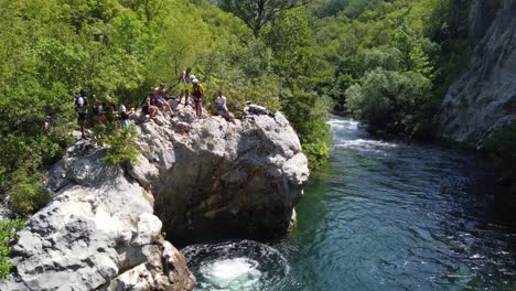 Rafting-Guide-encouraging-Girl-to-jumping-off-a-Rock-Cliff-on-Cetina-River,-Omis---Croatia