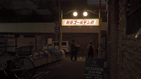 Japanischer-Männlicher-Arbeiter-Mit-Rucksack,-Der-Nachts-Durch-Die-Straße-In-Golden-Gai-Shinjuku-Nach-Hause-Geht