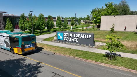 Vista-Aérea-De-La-Señal-De-Entrada-A-La-Universidad-De-South-Seattle-Con-Un-Autobús-Del-Metro-Del-Condado-De-King-Pasando-Por