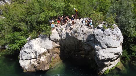 Junge-Menschen-Springen-Nach-Dem-Wildwasser-Rafting-Auf-Dem-Fluss-Cetina-In-Omis,-Kroatien,-Von-Einer-Klippe