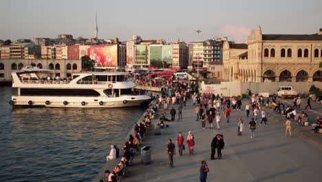 Istanbul,-Turkey---January-19,-2023:-A-walking-crowd-of-people-on-the-sunset-on-the-coast-of-Kadikoy-Square,-Istanbul-as-time-lapse