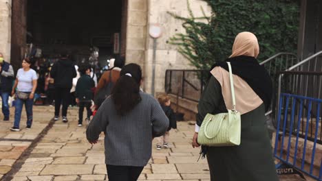 Muslim-women-walking-into-old-city-gate-together-in-middle-eastern-town-culture-islam-ethnic-world-travel