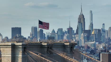 Bandera-Estadounidense-Ondeando-Frente-Al-Horizonte-Del-Centro-De-Manhattan-Con-El-Edificio-Empire-State