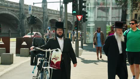 Orthodox-Jewish-men-walking-in-the-diverse-multicultural-Antwerp's-diamond-district,-Belgium---Slow-motion