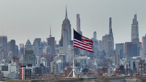 Amerikanische-Flagge-Weht-Vor-Dem-Empire-State-Building-Und-Der-Skyline-Von-Midtown-Manhattan