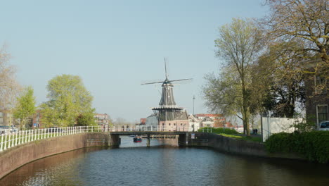 Sunlit-Historic-Windmill-by-the-Water-in-Haarlem,-Netherlands