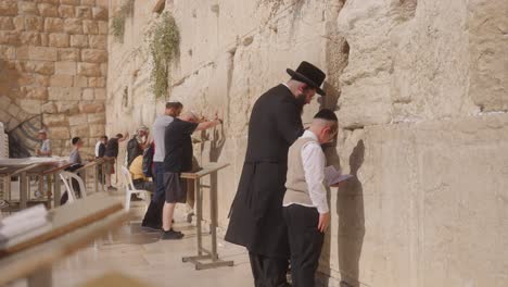 Padre-E-Hijo-Orando-En-El-Muro-De-Las-Lamentaciones,-Jerusalén,-Israel