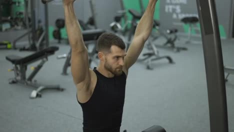 Male-training-back-and-hands-muscles-doing-pulls-weight-exercise-in-a-gym