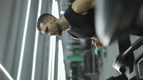 Sport-man-running-on-treadmill-machine-while-cardio-training-in-gym-club
