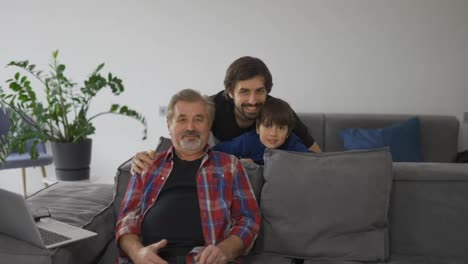 Portrait-of-happy-caucasian-three-generation-men-smiling-to-the-camera-at-home