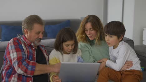 Großvater-Mit-Zwei-Enkelkindern-Und-Tochter,-Die-Per-Laptop-Einen-Videoanruf-Tätigen