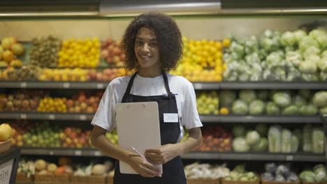 Portrait-of-African-American-female-staff-person-standing-with-tablet-in-supermarket-and-smiling