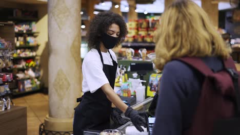 Portrait-of-female-worker-at-grocery-store-checkout-with-client