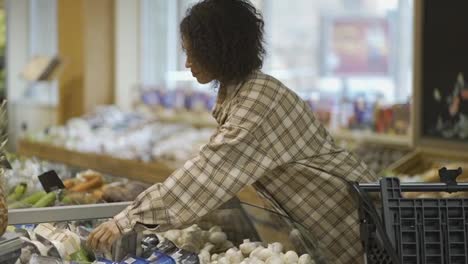 Mujer-Afroamericana-Con-Estilo-Eligiendo-Verduras-Empacadas-En-El-Supermercado