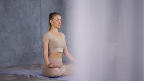Lotus-Pose-or-Padmasana-with-closed-eyes-and-holding-her-hands-in-Gyan-Mudra