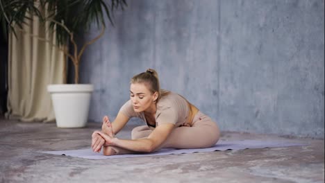 Attraktive-Weibliche-Yoga-Couch-Sitzt-In-Der-Kopf-bis-Knie-Pose-Und-Macht-Dann-Die-Gedrehte-Kopf-bis-Knie-Pose-Parivrtta-Janu-Sirsasana