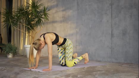 Female-coach-yoga-practicing-yoga-in-loft-studio