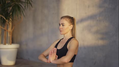 Entrenadora-De-Yoga-Hace-Gesto-De-Namaste-Con-Las-Manos-En-El-Interior-Por-La-Mañana