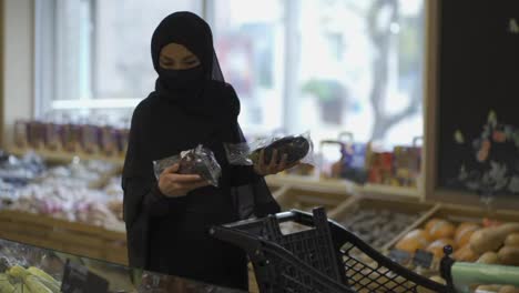 Frau-Im-Schwarzen-Niqab-Wählt-Auberginen-Im-Supermarkt-Aus