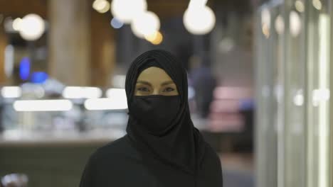 Porträt-Einer-Frau-In-Hijab-Und-Maske-Im-Supermarkt,-Die-Mit-Einem-Einkaufswagen-Steht