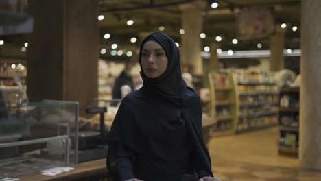 Una-Mujer-Con-Hijab-Toma-Un-Montón-De-Productos-Del-Estante-Del-Supermercado