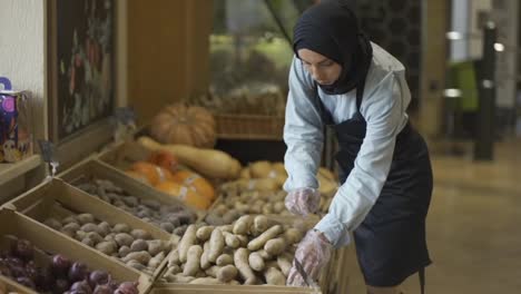 Frau-Im-Hijab-Füllt-Die-Kartoffeln-Auf-Dem-Vorrat-Im-Supermarkt-Auf