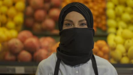 Porträt-Einer-Muslimischen-Supermarktangestellten,-Die-Mit-Der-Obstabteilung-Im-Hintergrund-Steht